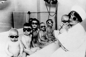 Crianças e enfermeira com proteção ocular são expostas a uma «lâmpada solar» para o tratamento do raquitismo. [1920] ©Hospital Johns Hopkins, Baltimore.